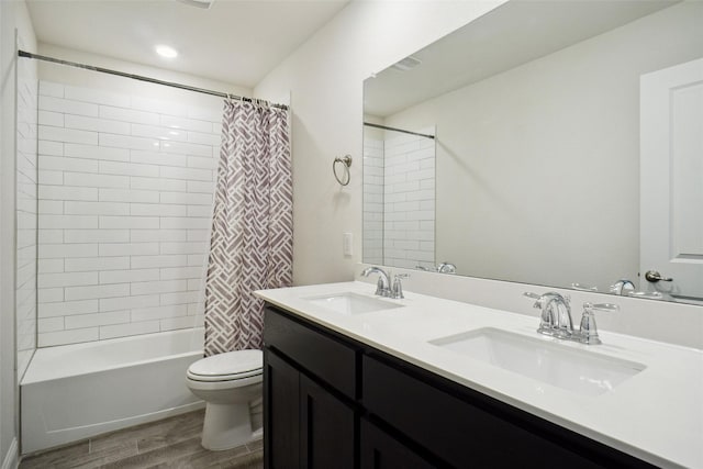 full bathroom featuring wood-type flooring, shower / bath combo, vanity, and toilet