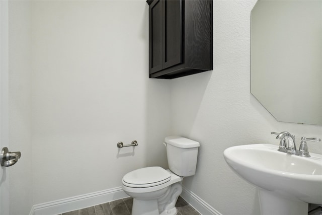 bathroom with hardwood / wood-style floors, sink, and toilet