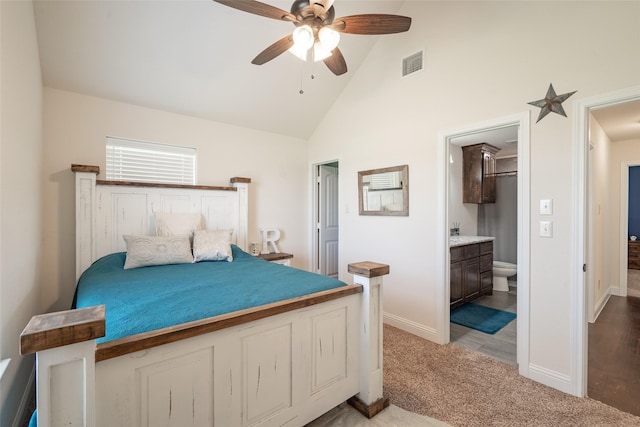 carpeted bedroom featuring ensuite bath, high vaulted ceiling, and ceiling fan