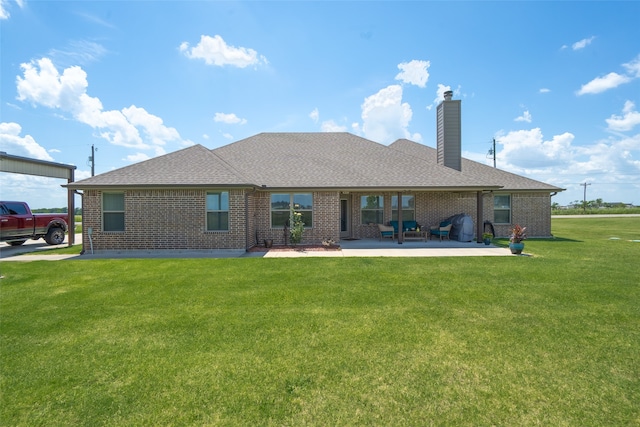 rear view of property with a yard and a patio