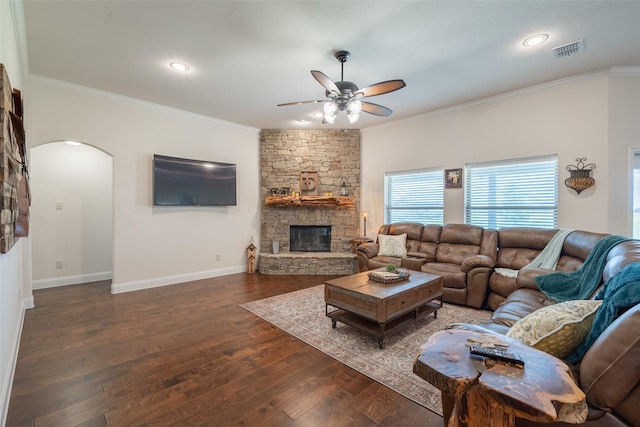 living room featuring ceiling fan, a fireplace, ornamental molding, and dark hardwood / wood-style flooring