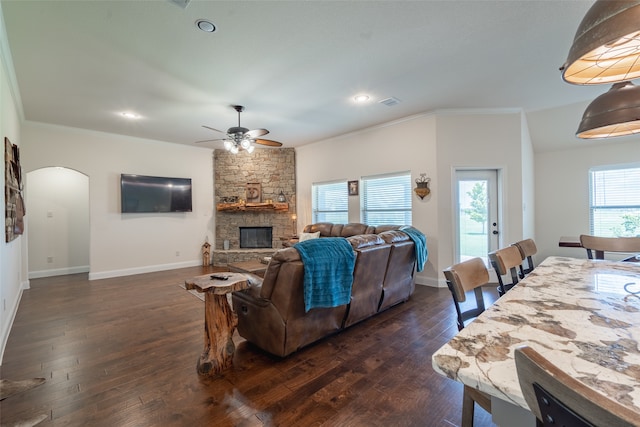 living room featuring ornamental molding, dark hardwood / wood-style floors, ceiling fan, and a fireplace