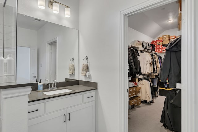 bathroom featuring vanity and lofted ceiling