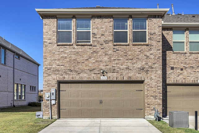 view of front facade featuring a garage and central air condition unit