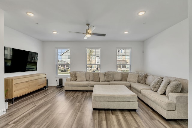 living room featuring ceiling fan, hardwood / wood-style floors, and a wealth of natural light