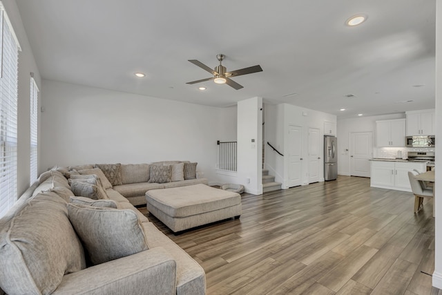 living room featuring ceiling fan and light wood-type flooring