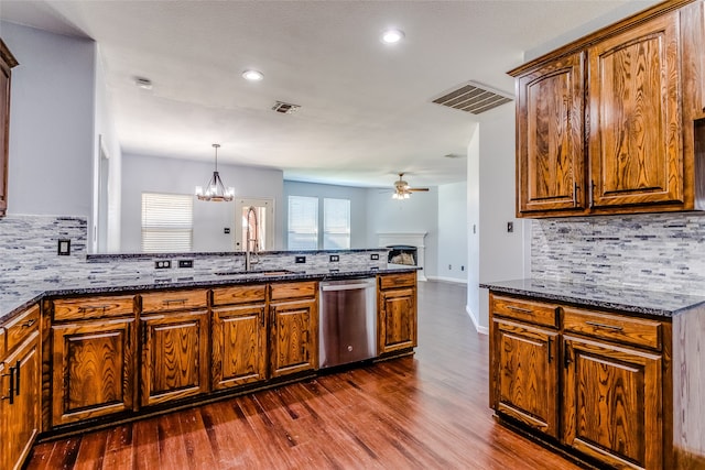 kitchen with dishwasher, dark hardwood / wood-style flooring, sink, and dark stone countertops