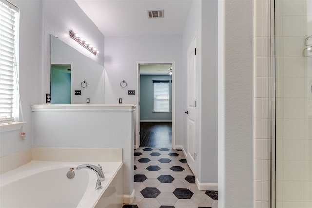 bathroom featuring hardwood / wood-style floors, plenty of natural light, and a tub