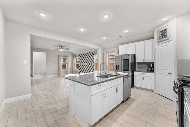 kitchen with white cabinets, an island with sink, stainless steel appliances, and sink