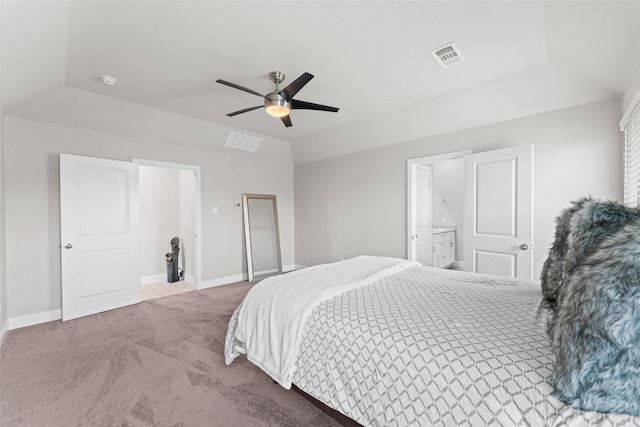 carpeted bedroom with ceiling fan, connected bathroom, and a tray ceiling