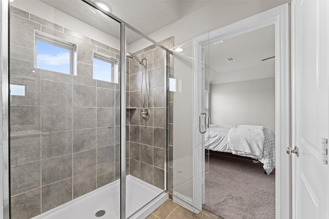 bathroom featuring tile patterned floors and a shower with shower door