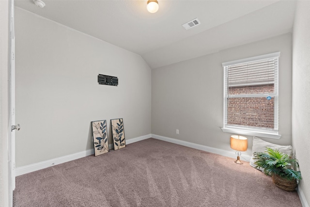 carpeted empty room featuring lofted ceiling