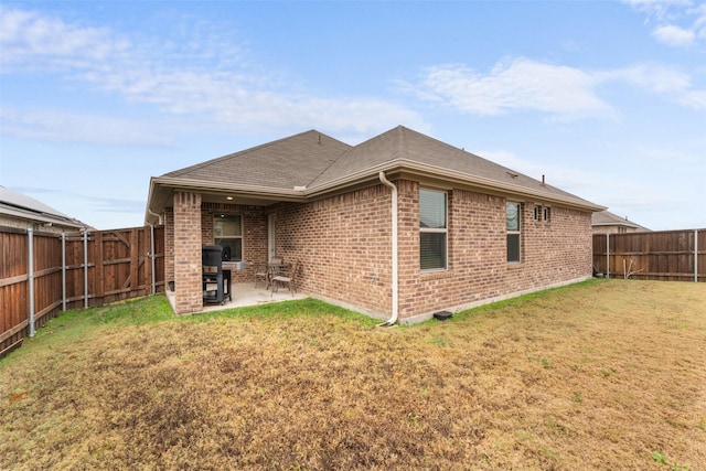 rear view of house featuring a lawn and a patio area