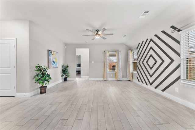 unfurnished living room with a wealth of natural light and ceiling fan