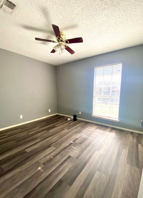 unfurnished room with ceiling fan, dark hardwood / wood-style flooring, and a textured ceiling