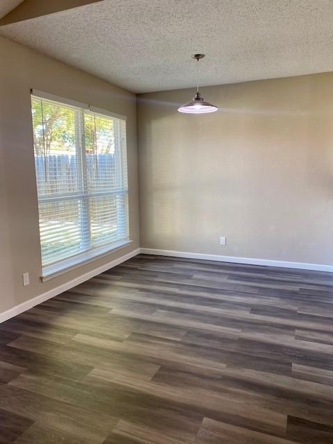 unfurnished dining area featuring dark hardwood / wood-style flooring and a textured ceiling