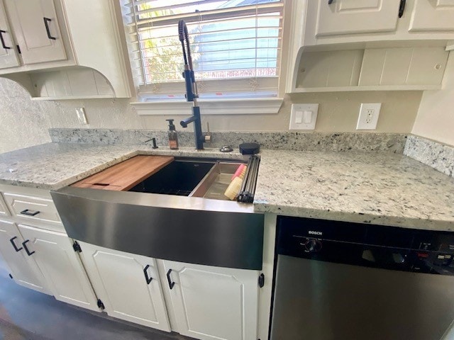 kitchen with dishwasher, white cabinetry, light stone countertops, and sink