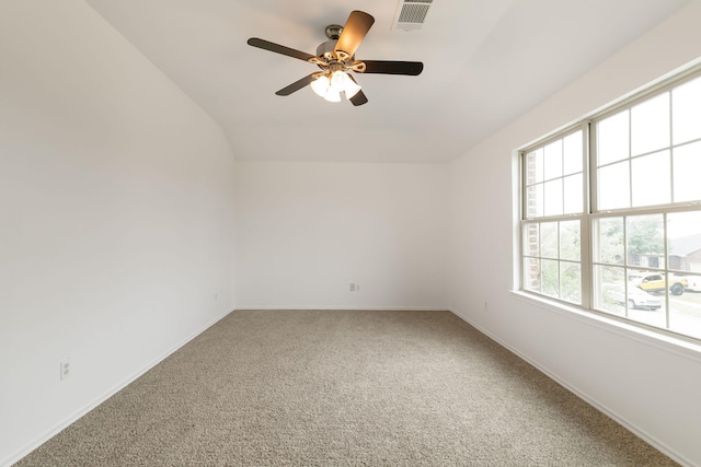 carpeted empty room with vaulted ceiling, ceiling fan, and a wealth of natural light