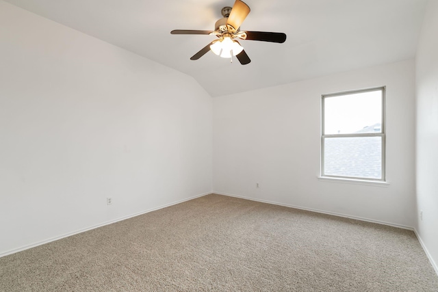 carpeted spare room featuring ceiling fan and vaulted ceiling