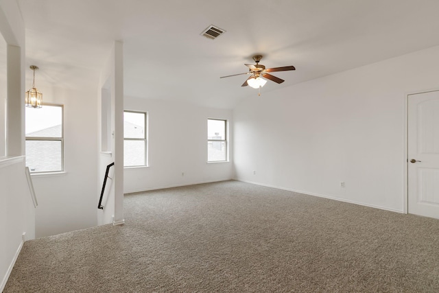 unfurnished room with ceiling fan with notable chandelier and carpet floors