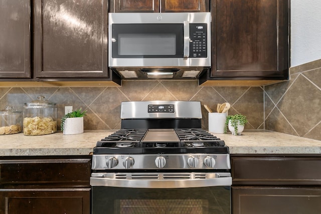 kitchen with stainless steel appliances, dark brown cabinets, and backsplash