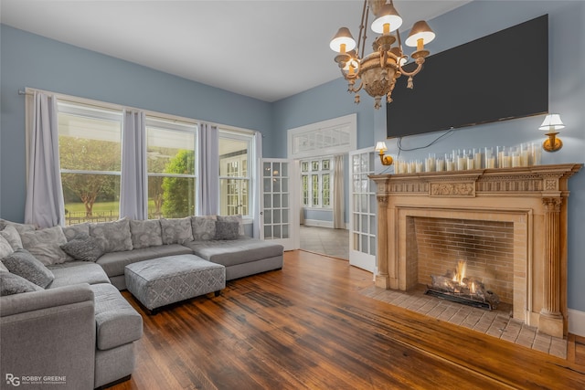 living room with hardwood / wood-style floors, a healthy amount of sunlight, and a notable chandelier