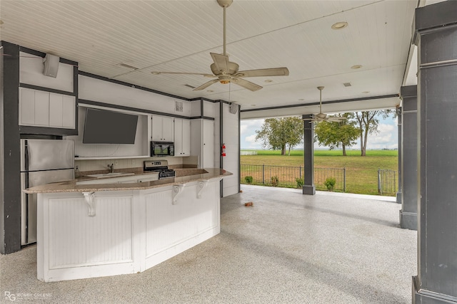 kitchen featuring sink, decorative light fixtures, a breakfast bar area, white cabinets, and appliances with stainless steel finishes