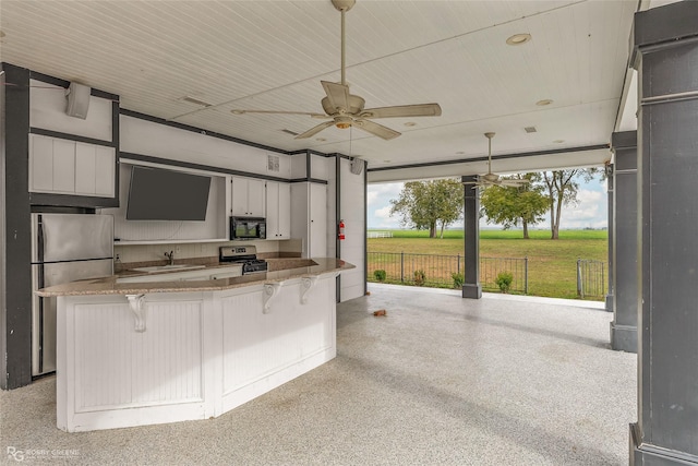 kitchen with sink, ceiling fan, hanging light fixtures, stainless steel appliances, and white cabinets