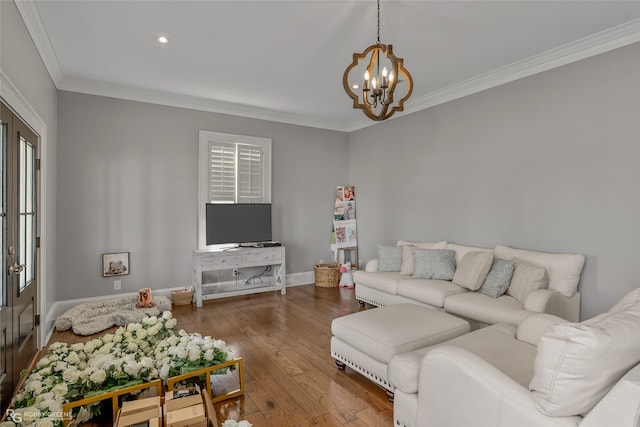 living room with hardwood / wood-style flooring, a notable chandelier, and crown molding