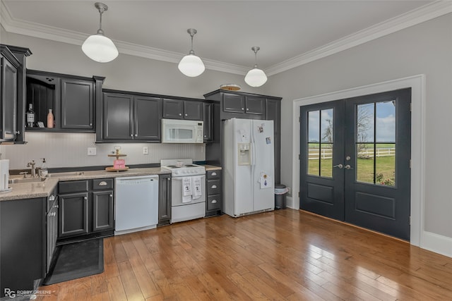 kitchen with hardwood / wood-style floors, decorative light fixtures, white appliances, and french doors