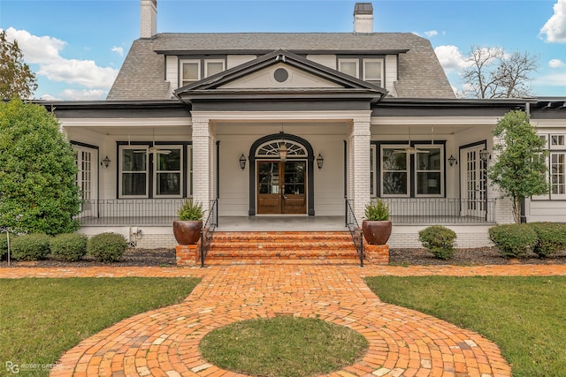 view of exterior entry featuring french doors and a porch