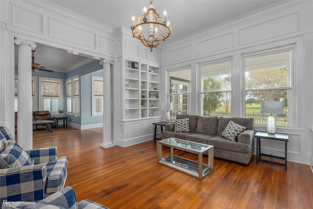 living room with built in shelves, ornamental molding, a wealth of natural light, and ornate columns