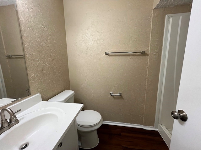 bathroom with vanity, toilet, and hardwood / wood-style floors