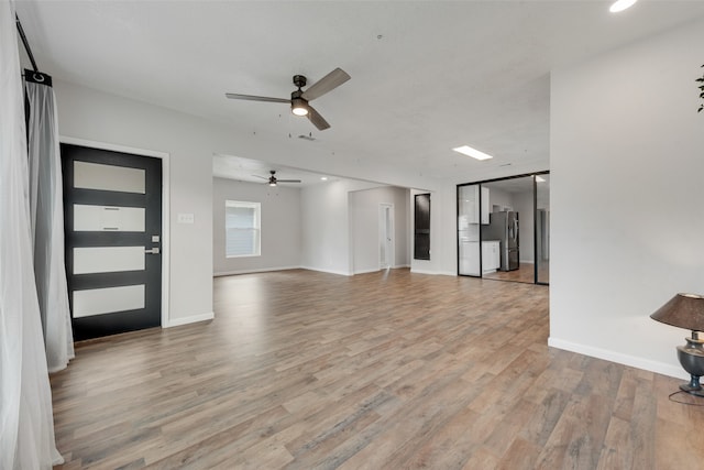 unfurnished living room featuring ceiling fan and light wood-type flooring