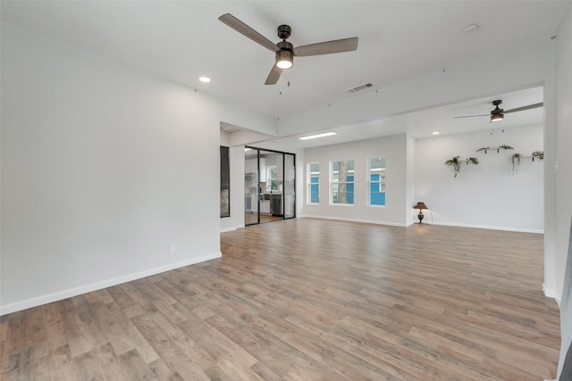 unfurnished living room featuring ceiling fan and light wood-type flooring