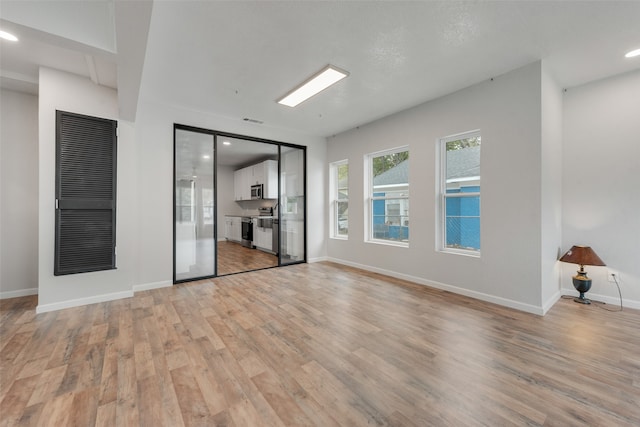 unfurnished room with light hardwood / wood-style floors