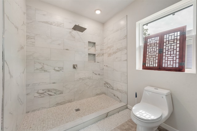 bathroom featuring a tile shower, tile patterned floors, french doors, and toilet