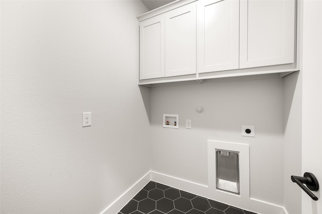 laundry room with baseboards, hookup for a washing machine, dark tile patterned flooring, cabinet space, and hookup for an electric dryer