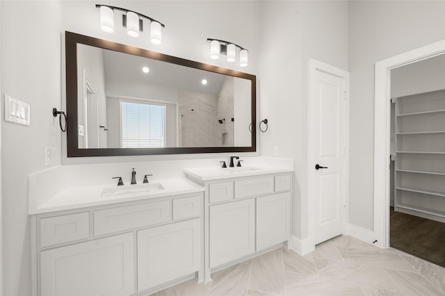 bathroom with double vanity, a sink, a tile shower, and recessed lighting