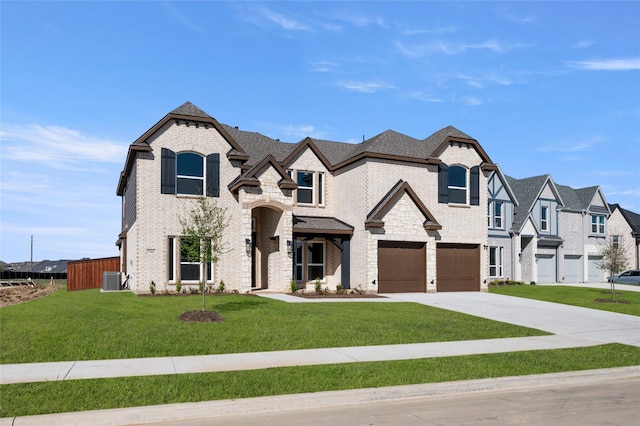 french country home with brick siding, fence, a garage, concrete driveway, and a front yard