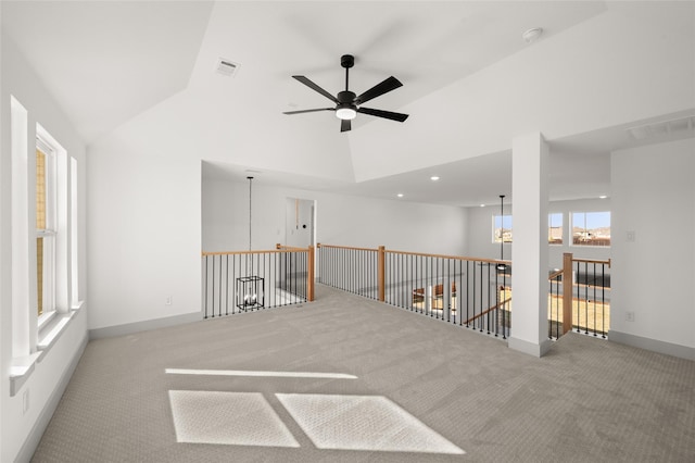 empty room featuring carpet flooring, a ceiling fan, high vaulted ceiling, visible vents, and baseboards