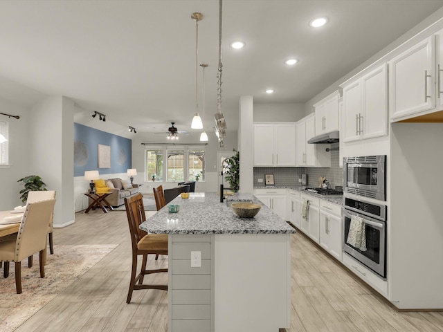 kitchen with ceiling fan, white cabinetry, light stone counters, and stainless steel appliances