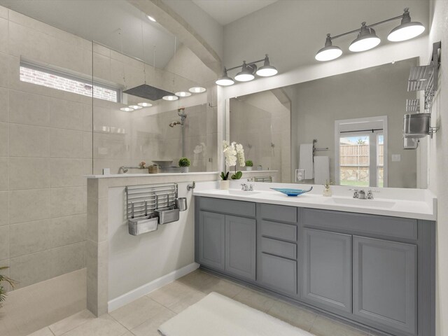 bathroom featuring vanity, tile patterned floors, and a tile shower