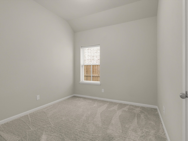 spare room with lofted ceiling and carpet flooring