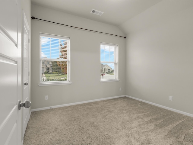 empty room with light carpet and vaulted ceiling