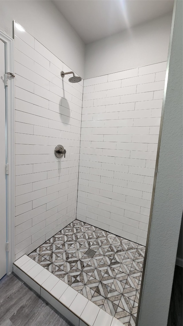 bathroom featuring hardwood / wood-style floors and a tile shower