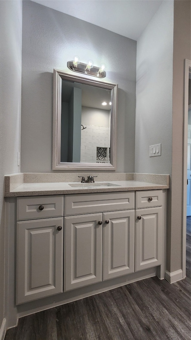 bathroom featuring vanity, a shower, and wood-type flooring