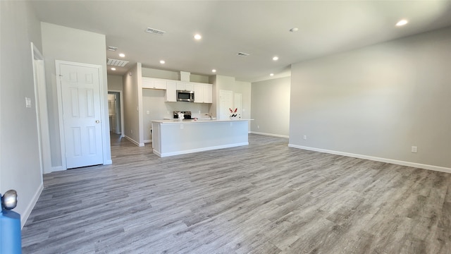 unfurnished living room with light hardwood / wood-style floors and sink