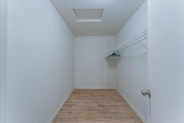 walk in closet with light hardwood / wood-style floors