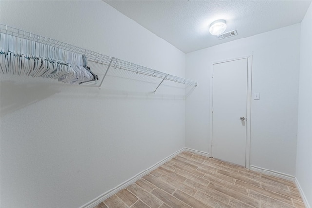 spacious closet with light hardwood / wood-style flooring